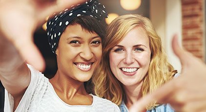 Two women with porcelain veneers smiling