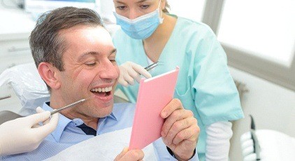 Man admiring his new dental implants in Kernersville