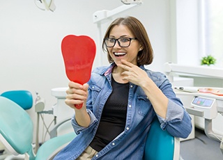 Young woman admiring her new dental implants in Kernersville