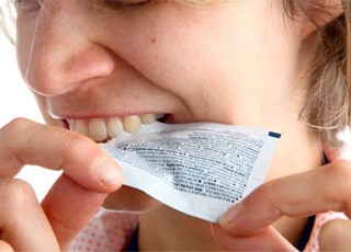 a person using her teeth to open packaging 