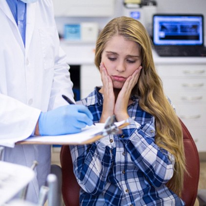 A woman discussing dental implant salvage with her dentist