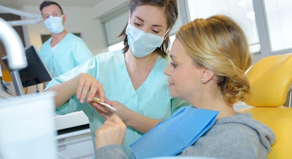 A woman listening to her periodontist explain whether she has gum disease or not