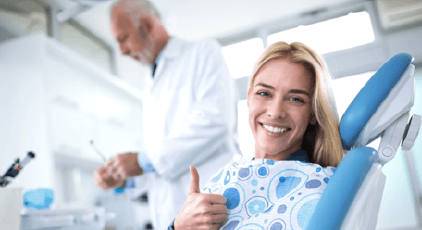 Woman giving thumbs up after root canal therapy