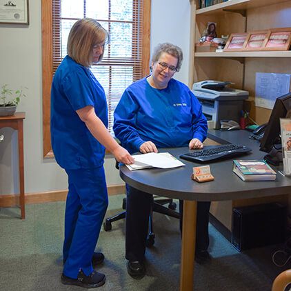 Doctor Walker and dental team member talking after dentures treatment plan