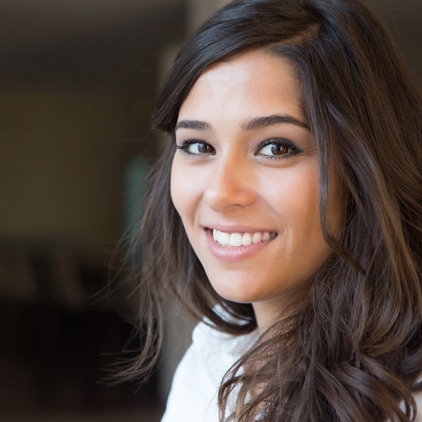 Woman smiling after receiving tooth colored fillings