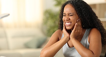 Woman sitting at desk, experiencing jaw pain