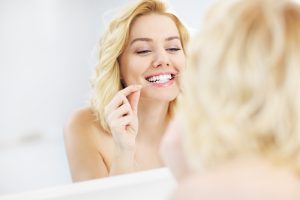 woman flossing teeth