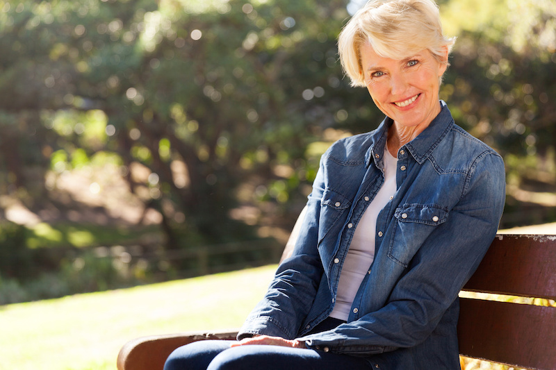 attractive senior woman sitting on a bench outdoors